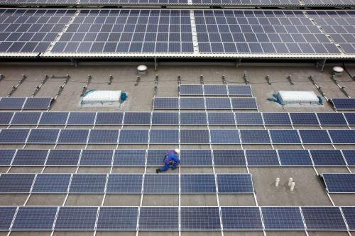 A stock image of photovoltaic panels on the roof of a large warehouse